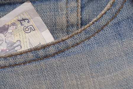 Macro photograph of £5 sterling in a Jeans pocket.