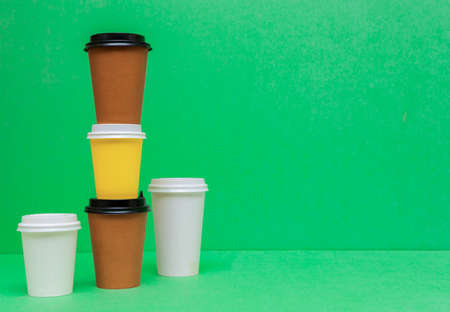 Paper cups for coffee with lids on a green background