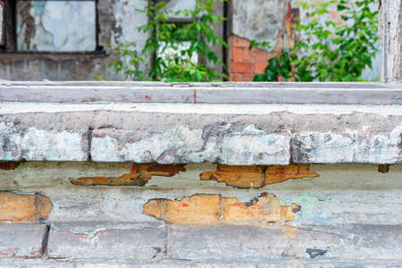 Part of the window sill and walls of an old half-destroyed building. Brick and plaster.
