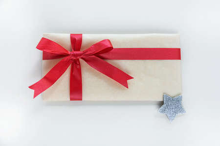 A kraft paper envelope tied with a red festive ribbon is meant to be a gift for Christmas or New...