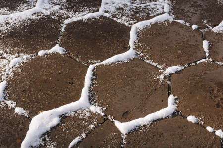 Nicely covered with snow pavement in the form of honeycombs.の写真素材