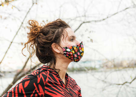 A woman makes a morning jog in the fresh air wearing a mask. The mask protects against dust and...