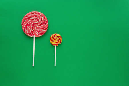 Big lollipop and small lollipop on a green background. New Year and Christmas concept. Flat lay.の写真素材
