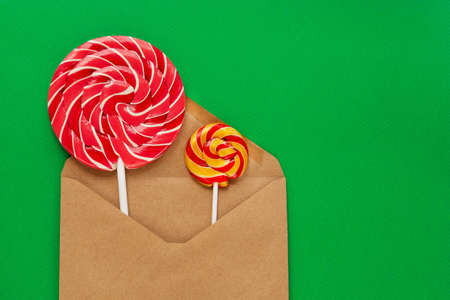 Two lollipops are included in a brown blank envelope. Gift for Christmas and New Year. Flat lay. There is room for text.の写真素材