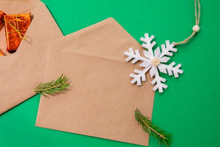 Christmas composition consisting of brown envelopes, snowflakes, spruce branch, gift. Flat lay....