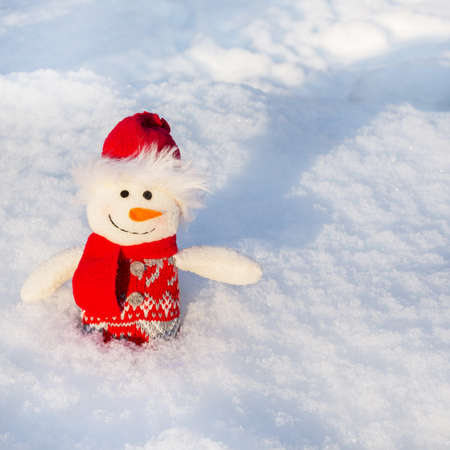 A snowman stands against a background of white, clean snow. Concept of New Year and Christmas.