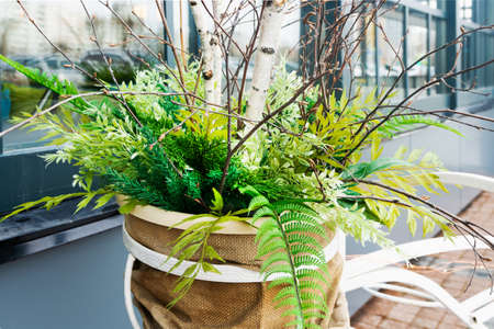 A beautiful spring arrangement of tree branches and bushes in a decorated pot decorates the entrance...