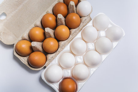 Brown and white eggs in cardboard boxes.