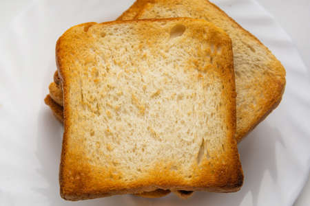Several slices of white bread are prepared for breakfast. Put crispy toasts on a plate. View from aboveの写真素材