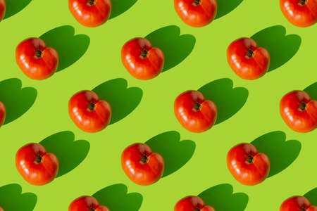 Pattern of red tomatoes with shadow on a green background. Seamless pattern.の写真素材
