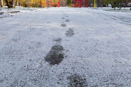 Tracks of footprints from shoes in the snow in a winter park.