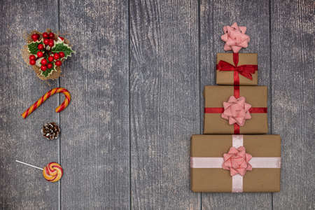 Holiday gifts and lollipops on a brown wooden background. New Year and Christmas concept. Flat lay.の写真素材