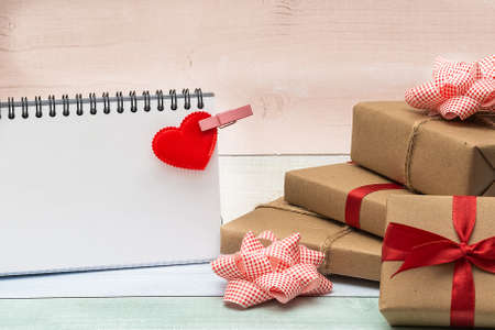 Blank notepad, gifts and heart on a colored wooden background. Valentine's Day concept.の写真素材