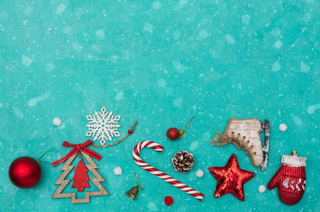 Background with Christmas attributes. Candy cane, star, snowflake, wooden Christmas tree on a green background. Flat lay. Copy space.の写真素材