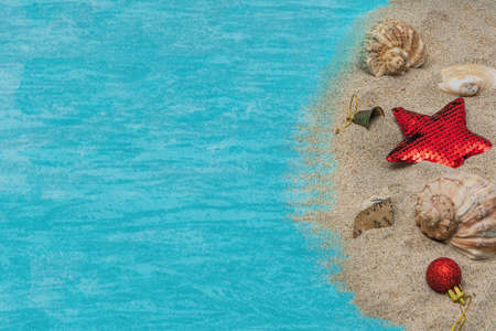 Sweets, gifts, seashells on the sand by the sea. Concept of travel to the sea in Christmas and New Year.の写真素材