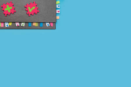 Gray weekly planner with bookmarks and puzzles with symbols on a blue background. The concept of planning and solving complex problems for the development of business and personalityの写真素材