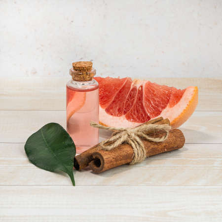 Bottle of grapefruit essential oil and cinnamon. Aromatherapy. Alternative medicine.