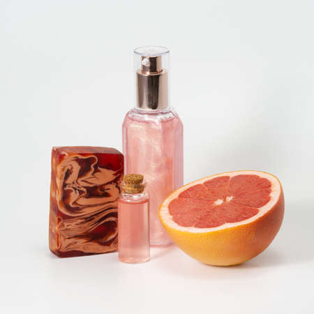 Grapefruit pieces, pink shower gel, natural soap and essential oil. The concept of natural...