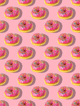 Repeating pattern of pink donuts on a pink background. flat lay.の写真素材