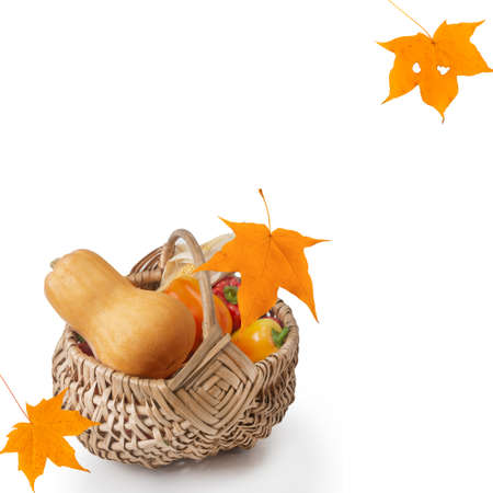 Autumn background with fresh vegetables in a wicker basket and maple leaves on a white background. isolated.の写真素材