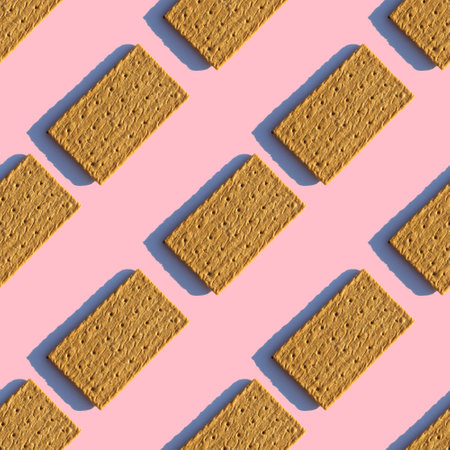 Pattern of sugar rectangular cookies with a shadow on a pink background. The cookies are placed diagonally.の写真素材