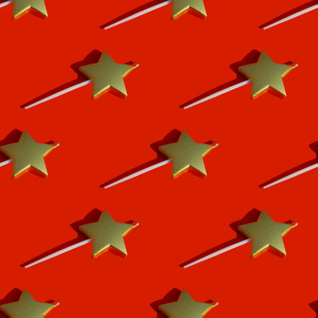 Repeating candle pattern in the form of a golden star with a shadow on a red background. New Year and Christmas concept.の写真素材