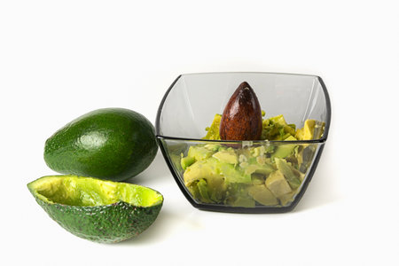 Avocado slices in a plate and a whole avocado on a white background. Healthy food concept.の写真素材