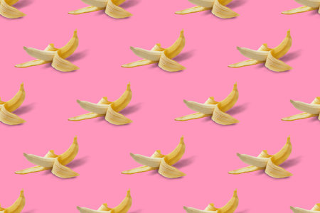 Pattern from a peeled ripe banana on a pink background.の写真素材