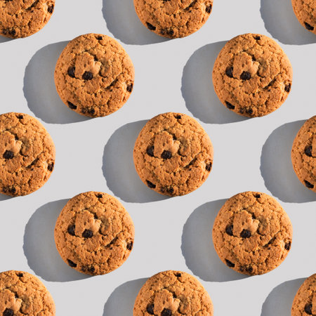 Oatmeal cookie pattern with sharp shadow on gray background.