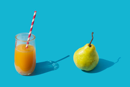 Pear juice with pulp and pear on a blue background. Healthy drink.の写真素材