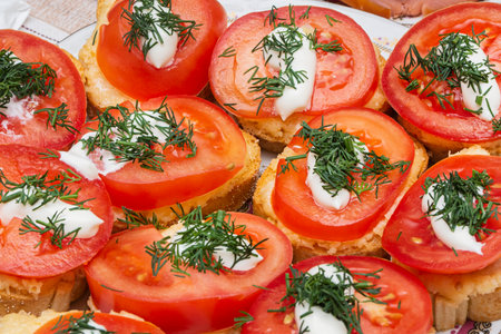 The plates contain delicious sandwiches with herbs, cheese and tomatoes.