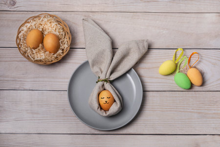 Festive Easter table setting. Dinner with rabbit and painted eggs. Pastel colors. Top view. Christian religious traditionの写真素材