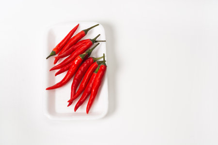 Group of red chili peppers in package on white background. Red chili peppers are packed for sale in the store.の写真素材