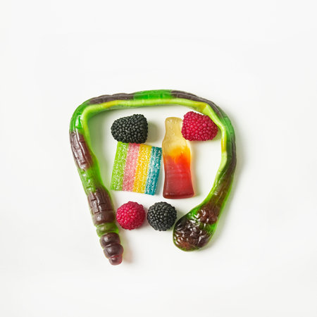 Gummy candies on a white background: snake, soda, raspberry, rainbow. Isolated. Flat lay.