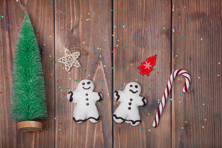 Christmas composition. A Christmas tree, two gingerbread men, and stars on a wooden background....