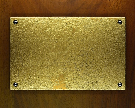 gold metal plate on wooden backgroundの写真素材