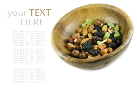 Nuts and dried fruit in a wooden bowl isolated on whiteの写真素材