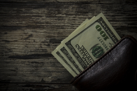 Wallet with hundred dollar banknotes, on wooden backgroundの写真素材