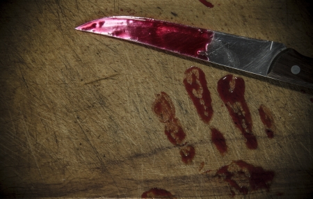 Grunge wooden background with a bloody hand print on the cutting boardの写真素材