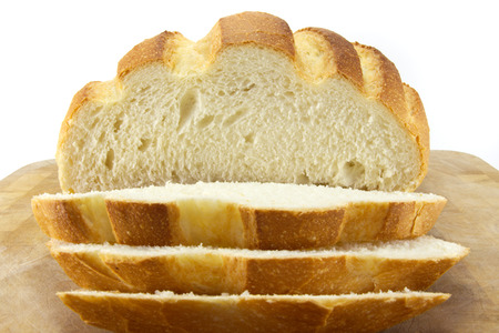 Fresh bread sliced on a wooden chopping board, white background.