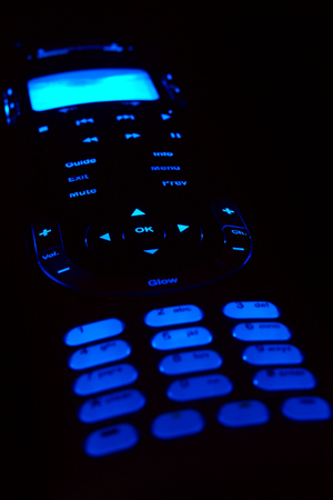 A glowing remote control on black background.の写真素材
