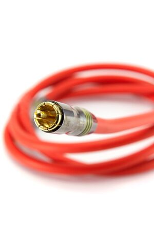 An orange audio cable, isolated on white. Focus on RCA connector, shallow DOF.