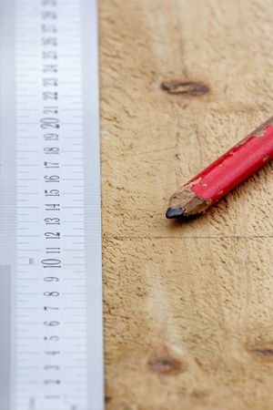 A carpenters ruler and pencil on a piece of timber, preparing to cut.の写真素材