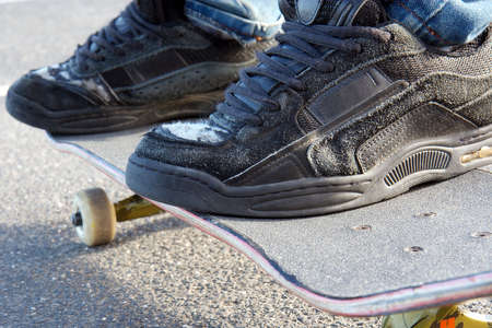 Riding a skateboard. Focus on worn front shoe.の写真素材