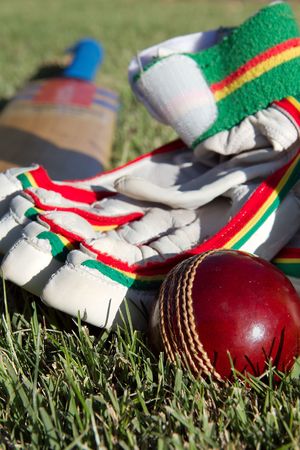 Cricket ball, bat and gloves on the field.の写真素材