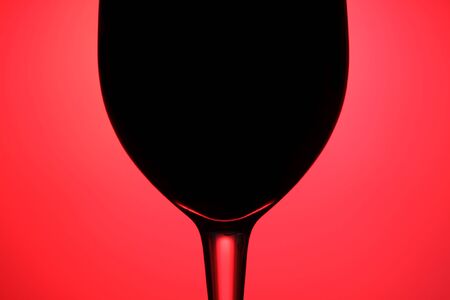 An abstract of a glass of wine on a red background.