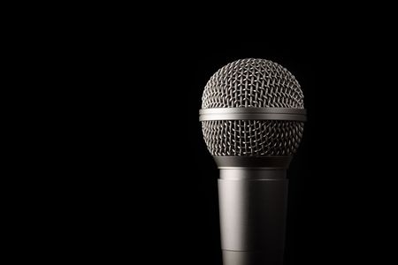 A modern dynamic microphone on a black background.の写真素材