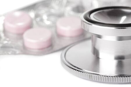 A stethoscope, isolated on a white background with an opened packet of pills.の写真素材