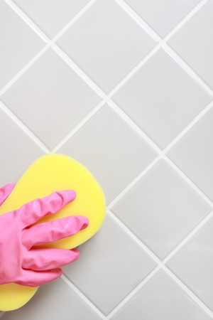 Hand and glove cleaning the bathroom tiles.の写真素材