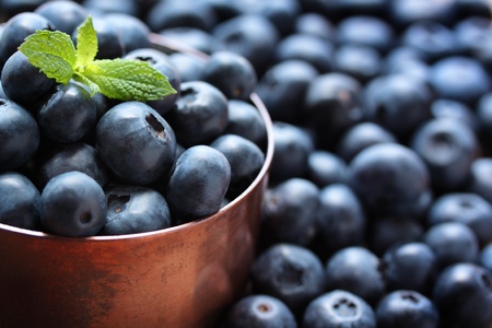 Fresh, ripe blueberries in a copper measuring cup. Fresh, ripe blueberries in a copper measuring cup.